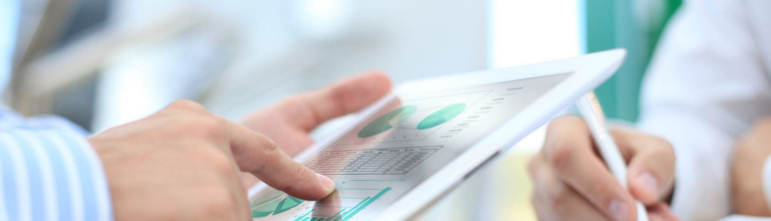 Image of human hand pointing at touchscreen in working environment at meeting